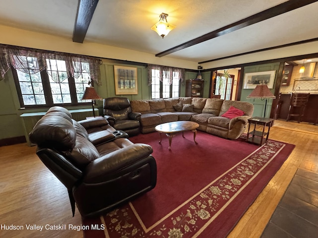 living area with hardwood / wood-style floors and beamed ceiling