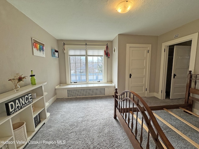 carpeted bedroom with radiator, visible vents, a textured ceiling, and baseboards