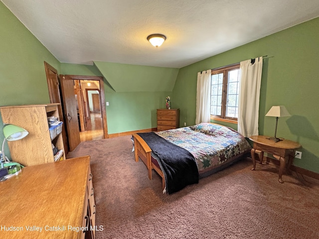 carpeted bedroom featuring lofted ceiling, baseboards, and a textured ceiling