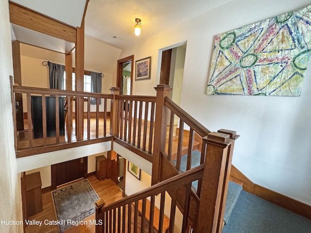 staircase featuring baseboards and wood finished floors