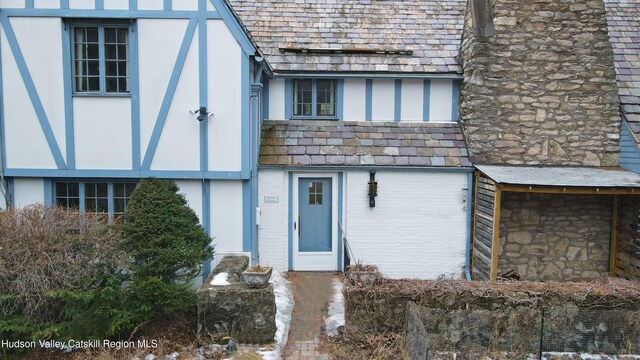 view of front of property with a high end roof, stucco siding, and stone siding