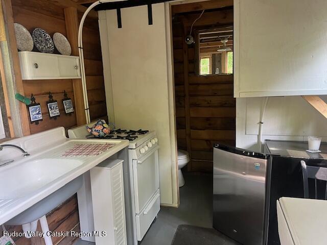 40 N Mountain, Copake Falls, NY 12517 - kitchen featuring white range with gas cooktop, freestanding refrigerator, finished concrete floors, and light countertops
