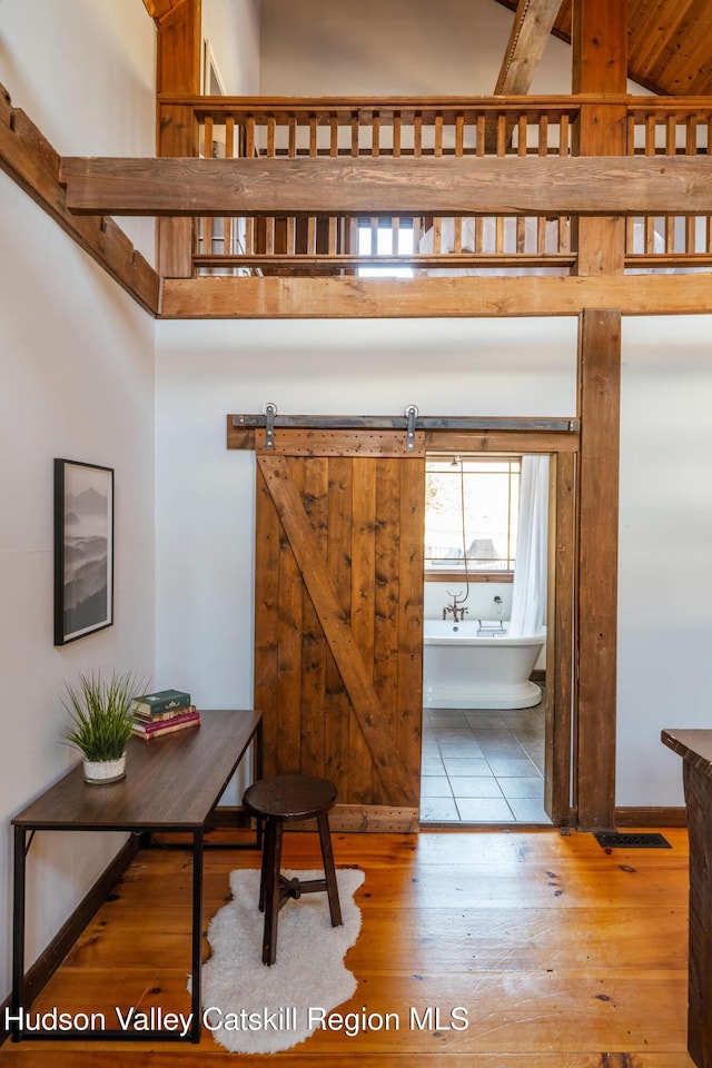 foyer entrance with a barn door and hardwood / wood-style flooring