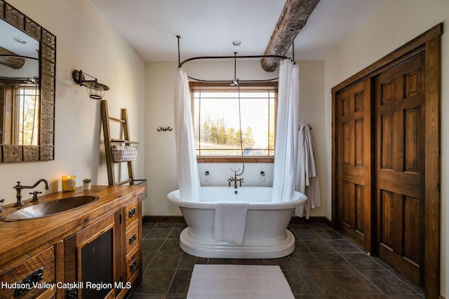 bathroom with tile patterned flooring, a freestanding bath, vanity, and baseboards