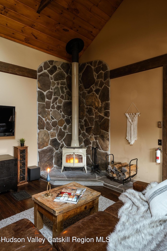 living room featuring hardwood / wood-style flooring, a wood stove, wooden ceiling, and vaulted ceiling