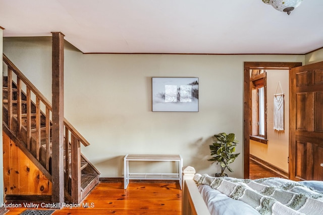 bedroom featuring crown molding, wood finished floors, and baseboards