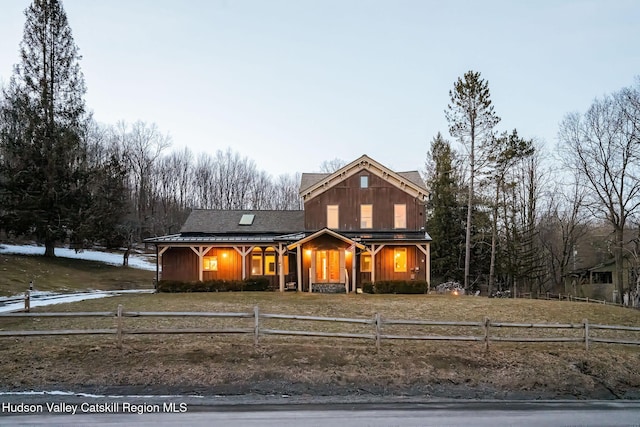 view of front of house with a fenced front yard, board and batten siding, and roof with shingles