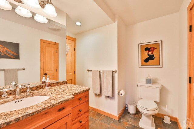 90 Club Rd, Windham, NY 12496 - bathroom with baseboards, toilet, vanity, and stone finish floors