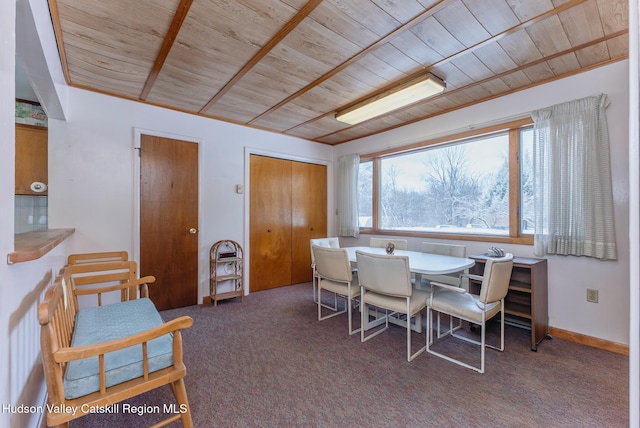 dining room featuring wood ceiling and carpet