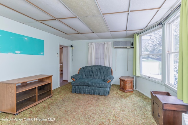 living area with a wall mounted AC and light colored carpet