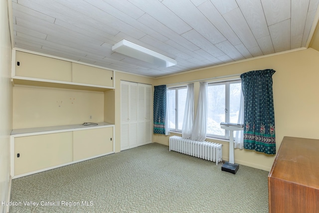 unfurnished bedroom with wooden ceiling, a closet, light colored carpet, crown molding, and radiator