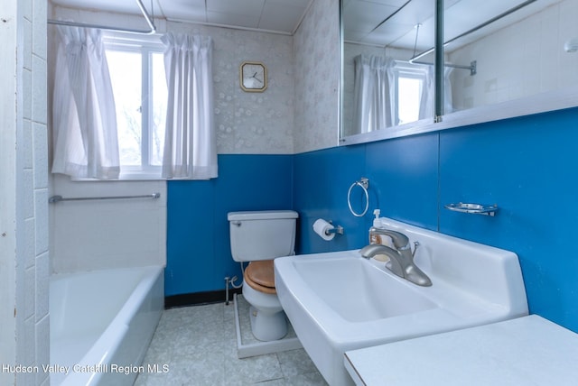 bathroom with tile patterned flooring, a wealth of natural light, shower / bath combo with shower curtain, and toilet