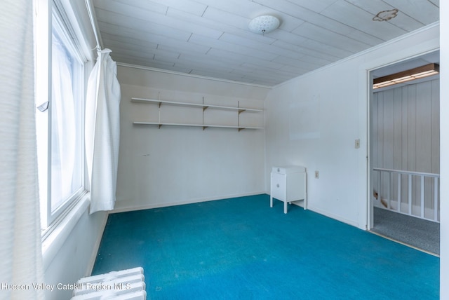 carpeted empty room with wooden ceiling and crown molding