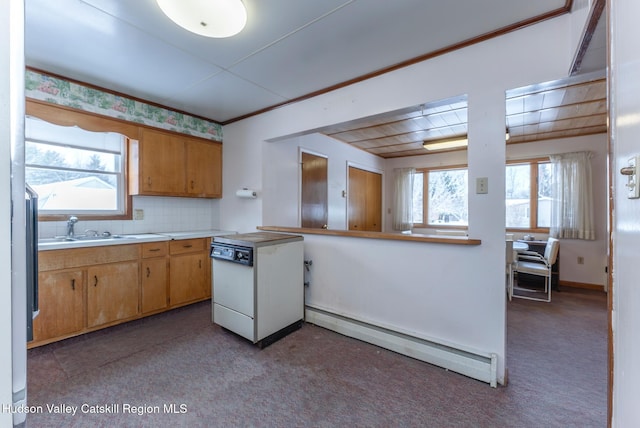 kitchen with decorative backsplash, baseboard heating, light colored carpet, stove, and sink