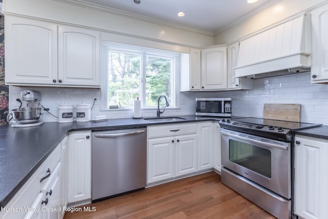 157 Hillside Ter, Kingston, NY 12401 - kitchen featuring appliances with stainless steel finishes, premium range hood, dark countertops, ornamental molding, and white cabinetry