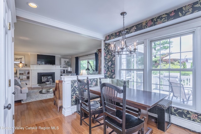 157 Hillside Ter, Kingston, NY 12401 - dining space with a chandelier, wood finished floors, crown molding, and a brick fireplace