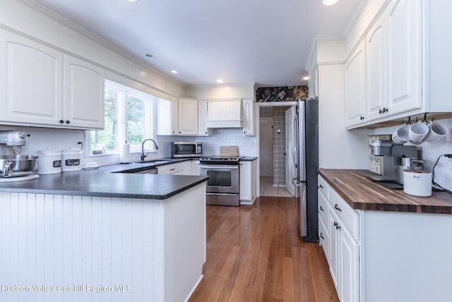 157 Hillside Ter, Kingston, NY 12401 - kitchen featuring appliances with stainless steel finishes, wooden counters, a peninsula, wood finished floors, and white cabinets