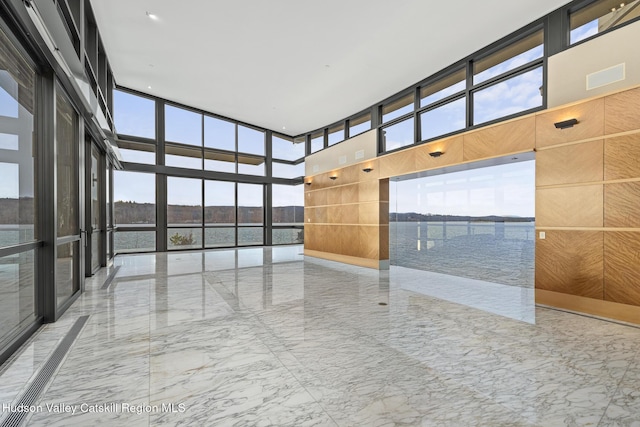 empty room featuring a water view and a towering ceiling