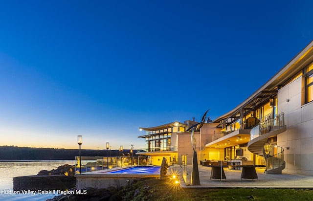 exterior space featuring a water view, a patio, and an outdoor hangout area