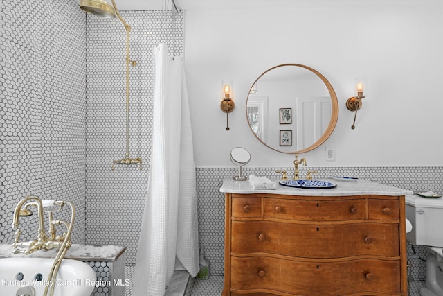 bathroom with vanity, tile walls, and toilet