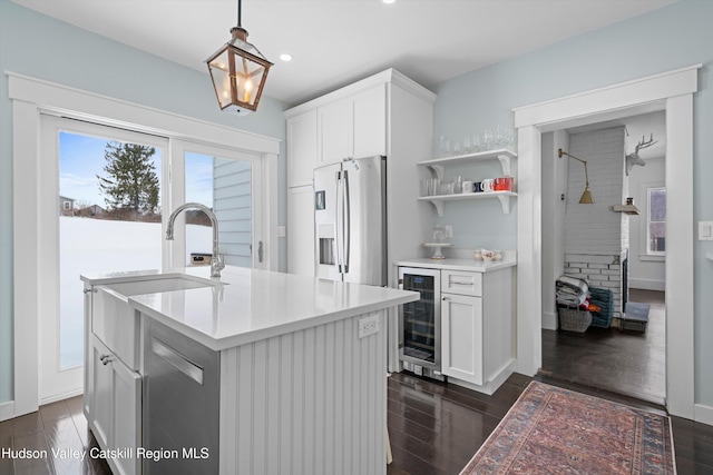 kitchen featuring an island with sink, white cabinets, wine cooler, hanging light fixtures, and stainless steel fridge with ice dispenser