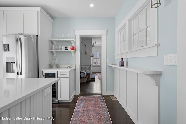 kitchen with stainless steel refrigerator with ice dispenser, wine cooler, white cabinets, and dark hardwood / wood-style flooring