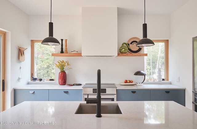 99 Cannon Cir, Woodstock, NY 12498 - kitchen with gray cabinetry, decorative light fixtures, light stone counters, stainless steel range with electric cooktop, and modern cabinets