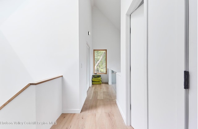 99 Cannon Cir, Woodstock, NY 12498 - hall featuring light wood-type flooring, high vaulted ceiling, baseboards, and an upstairs landing