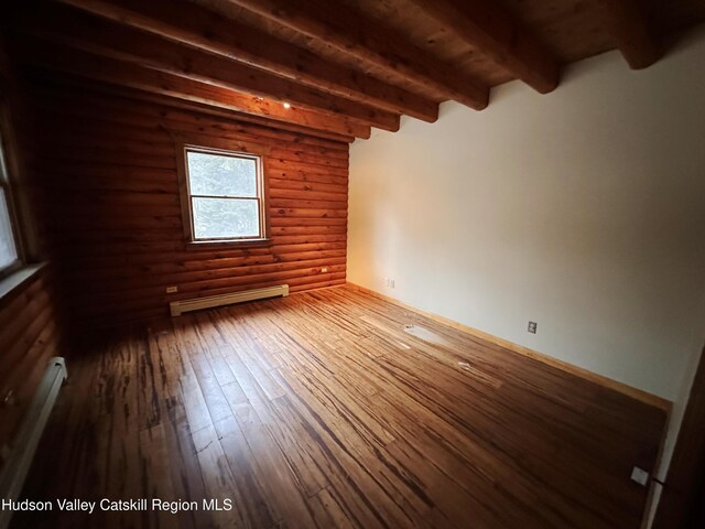 empty room featuring rustic walls, beam ceiling, hardwood / wood-style floors, and a baseboard radiator