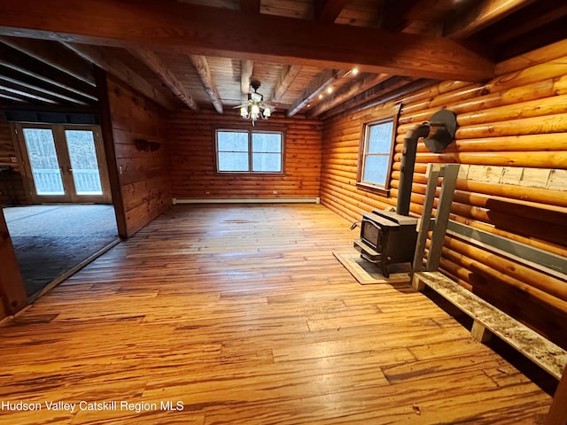 unfurnished living room featuring french doors, log walls, light hardwood / wood-style floors, wooden ceiling, and beamed ceiling