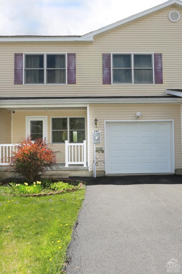 147 Skyview, Greenville, NY 12083 - view of front of property with covered porch, a garage, asphalt driveway, and a front yard