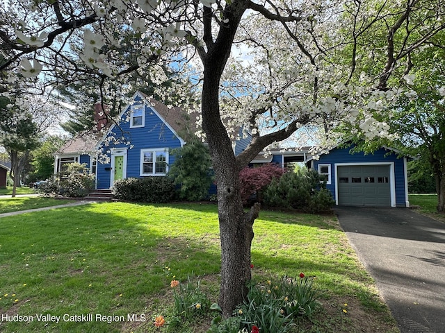 view of property hidden behind natural elements with asphalt driveway, an attached garage, and a front lawn