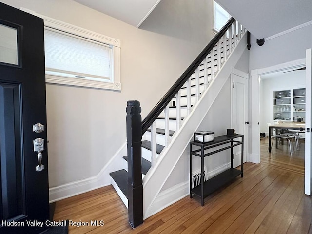 stairway with a healthy amount of sunlight and wood-type flooring