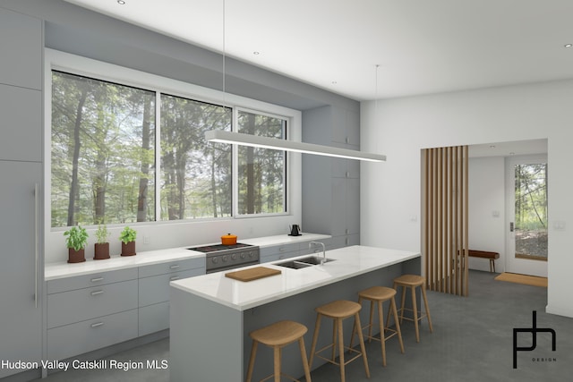 kitchen featuring a breakfast bar, sink, a kitchen island, and concrete flooring