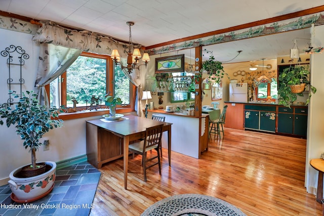 dining area featuring hardwood / wood-style flooring, ornamental molding, and a chandelier