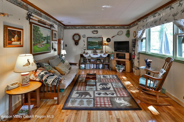 living room with light wood-type flooring and crown molding