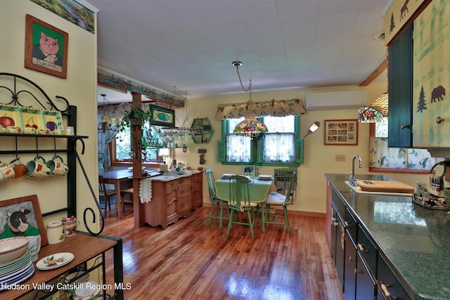 kitchen with plenty of natural light, dark hardwood / wood-style floors, an AC wall unit, and sink