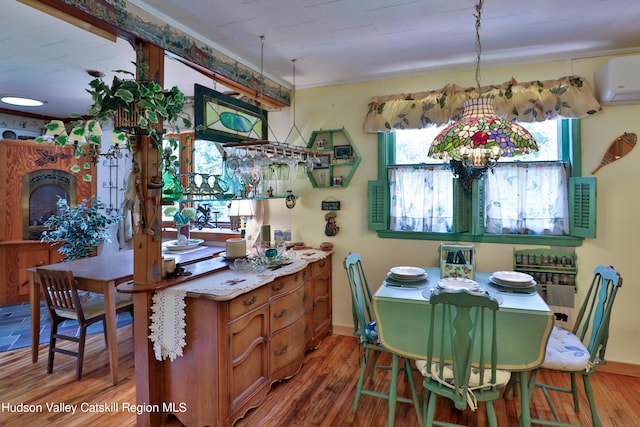 dining space featuring hardwood / wood-style flooring and a wall unit AC