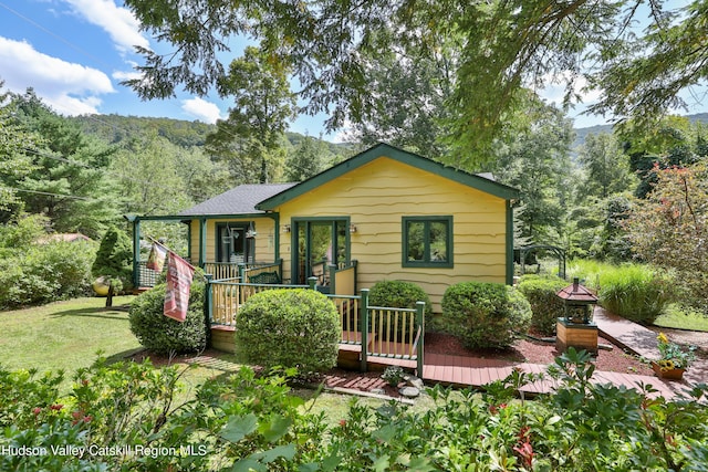 rear view of property with a lawn and a deck