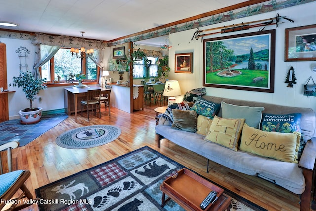 living room with hardwood / wood-style flooring, crown molding, and a chandelier