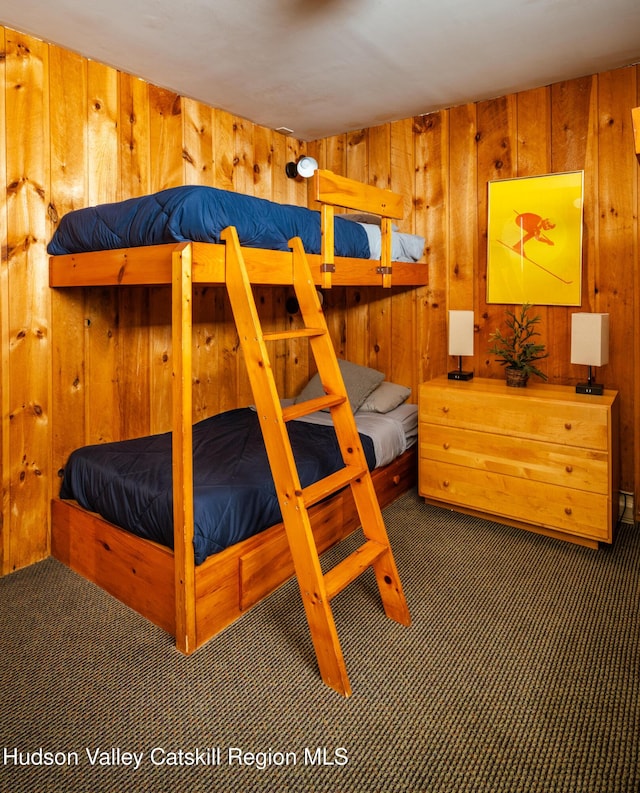 unfurnished bedroom with wood walls and dark colored carpet