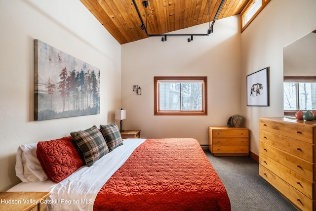 bedroom featuring lofted ceiling, dark carpet, wood ceiling, and baseboards