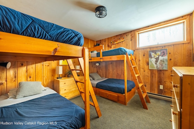 bedroom with a baseboard radiator, dark carpet, and wooden walls