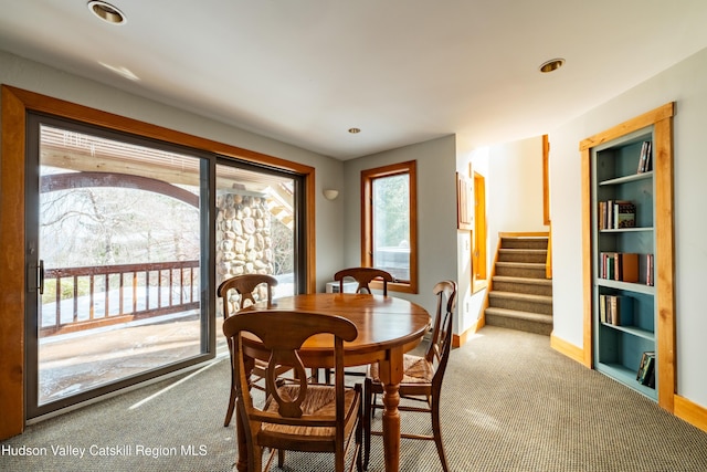 dining room with baseboards, stairs, built in features, and carpet flooring