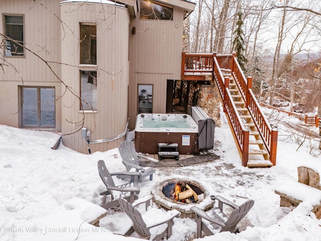 exterior space featuring an outdoor fire pit, stairway, a wooden deck, and a hot tub