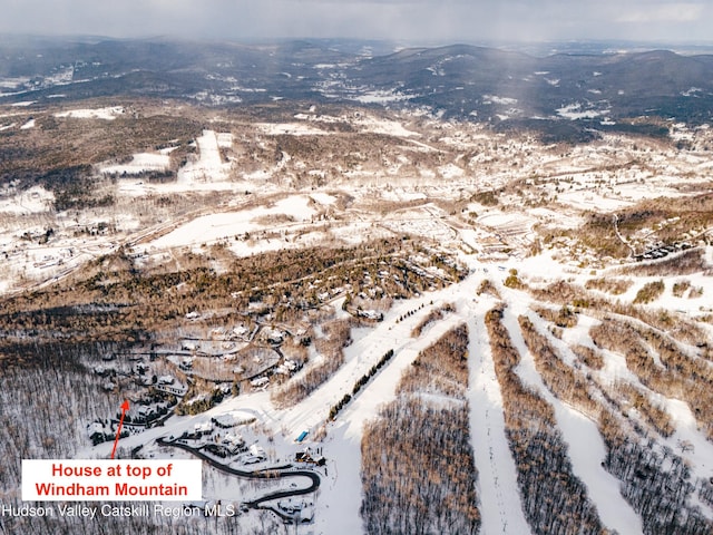 snowy aerial view with a mountain view