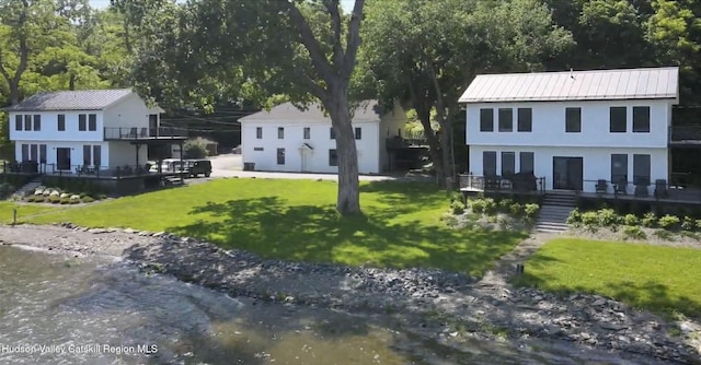 view of front of property with a water view and a front lawn