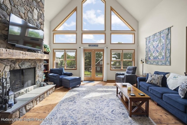16 Wang Dr, Copake, NY 12516 - living area featuring high vaulted ceiling, wood finished floors, a stone fireplace, and french doors