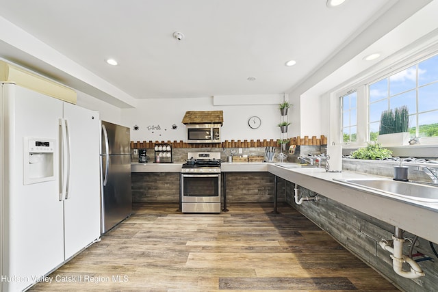 kitchen featuring recessed lighting, light countertops, light wood-type flooring, and stainless steel appliances