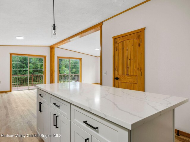 719 Allen Teator Rd, Durham, NY 12469 - kitchen with light stone counters, light wood-type flooring, vaulted ceiling, white cabinets, and recessed lighting